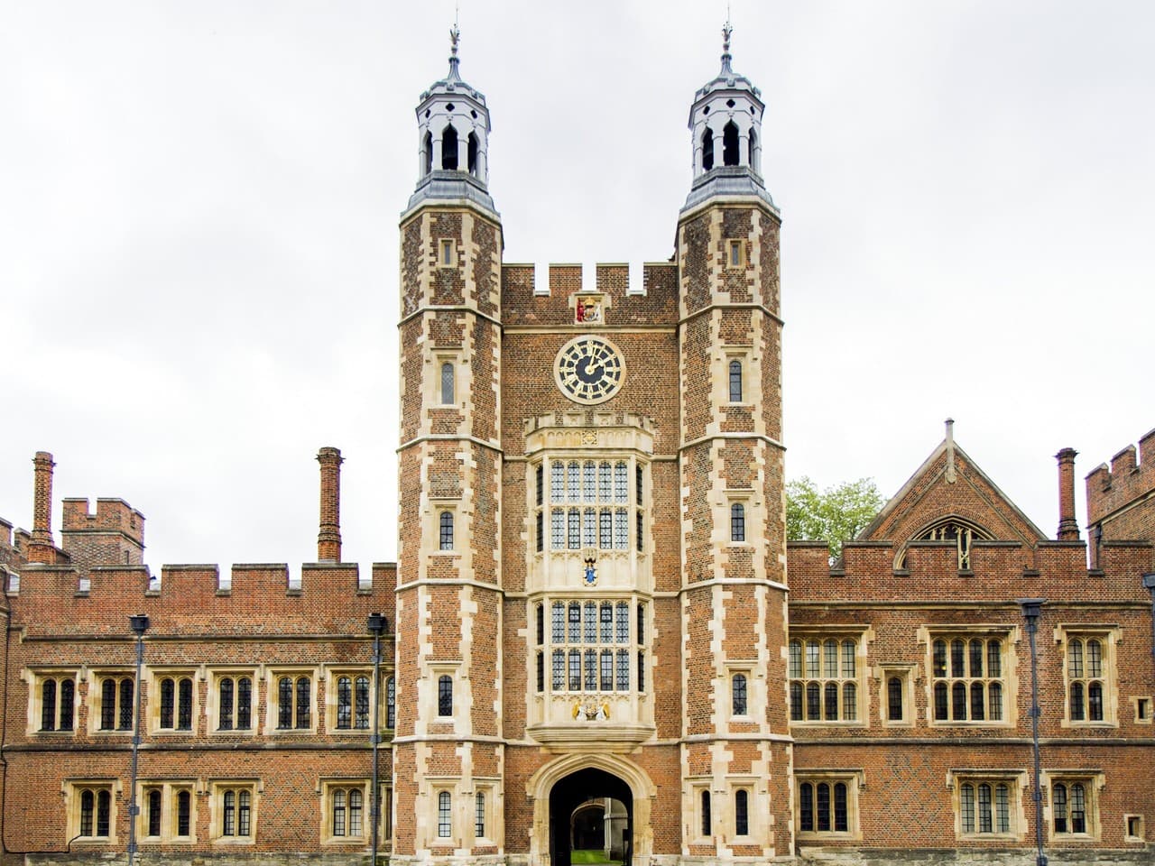 The clock tower and twin cupolas of Eton College, above its brick and stone entrance