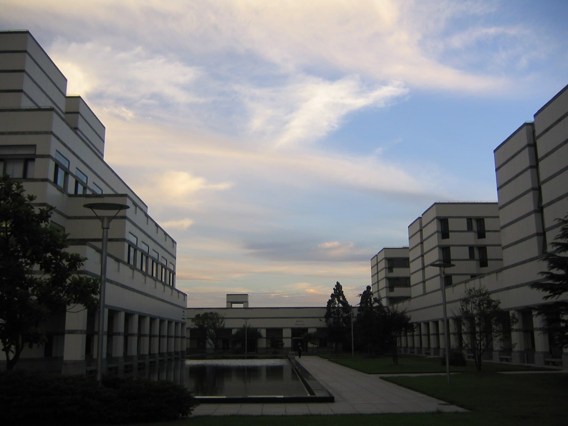 Pale campus buildings around a reflecting pool at CEIBS in Shanghai
