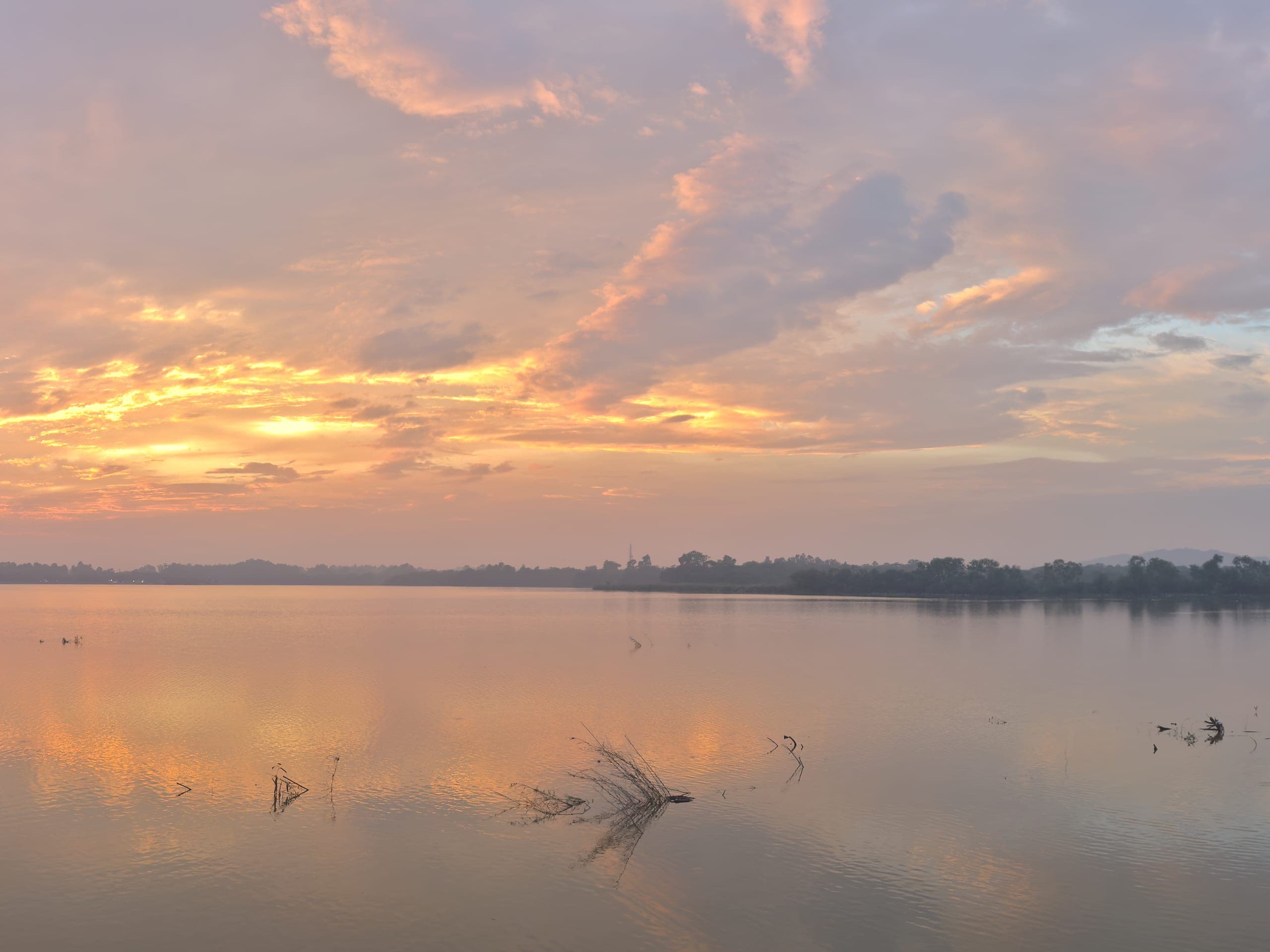 A calm lake under an orange and violet sunset sky