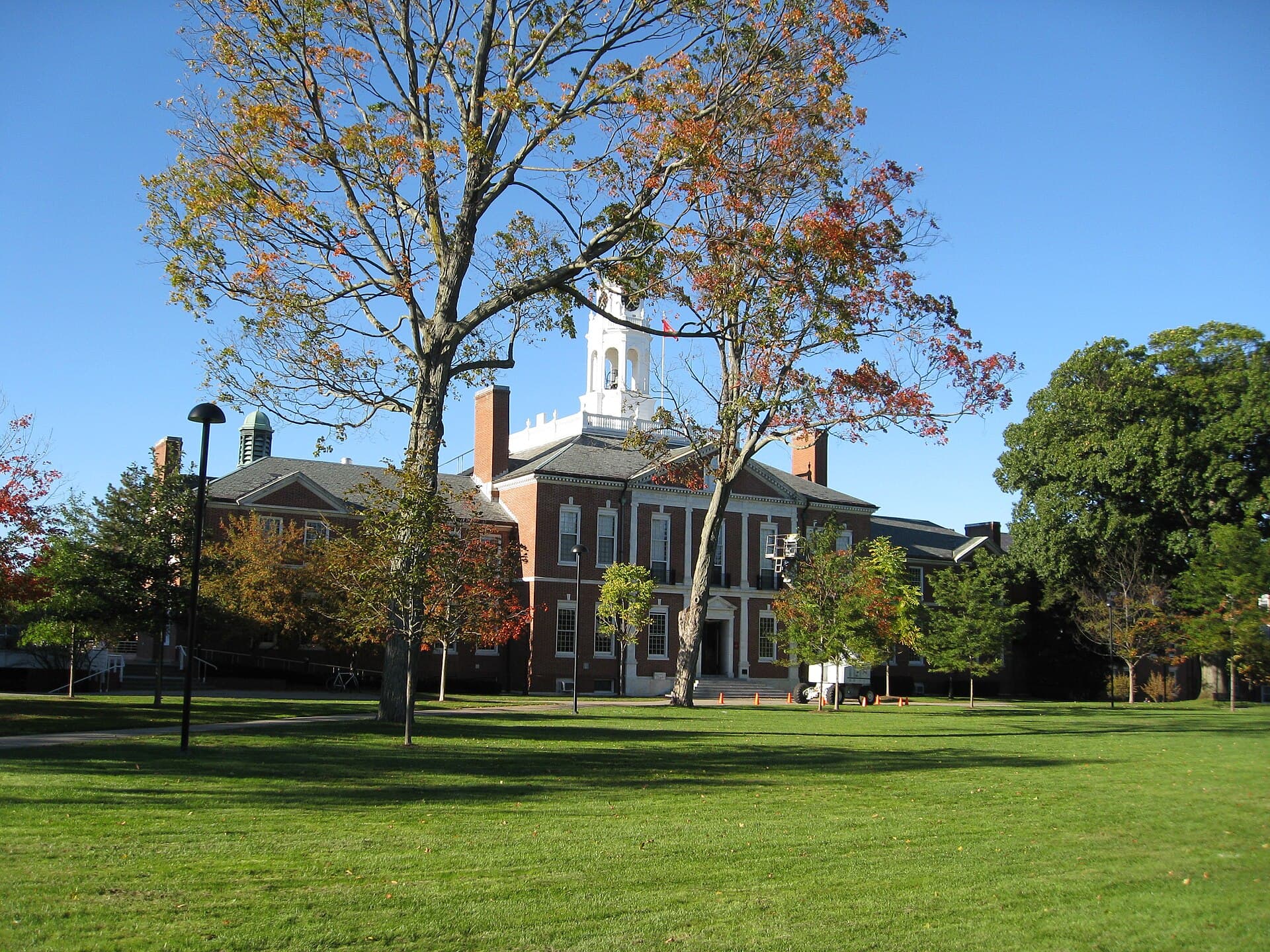 The brick Academy Building at Phillips Exeter Academy, with a white bell tower behind autumn trees