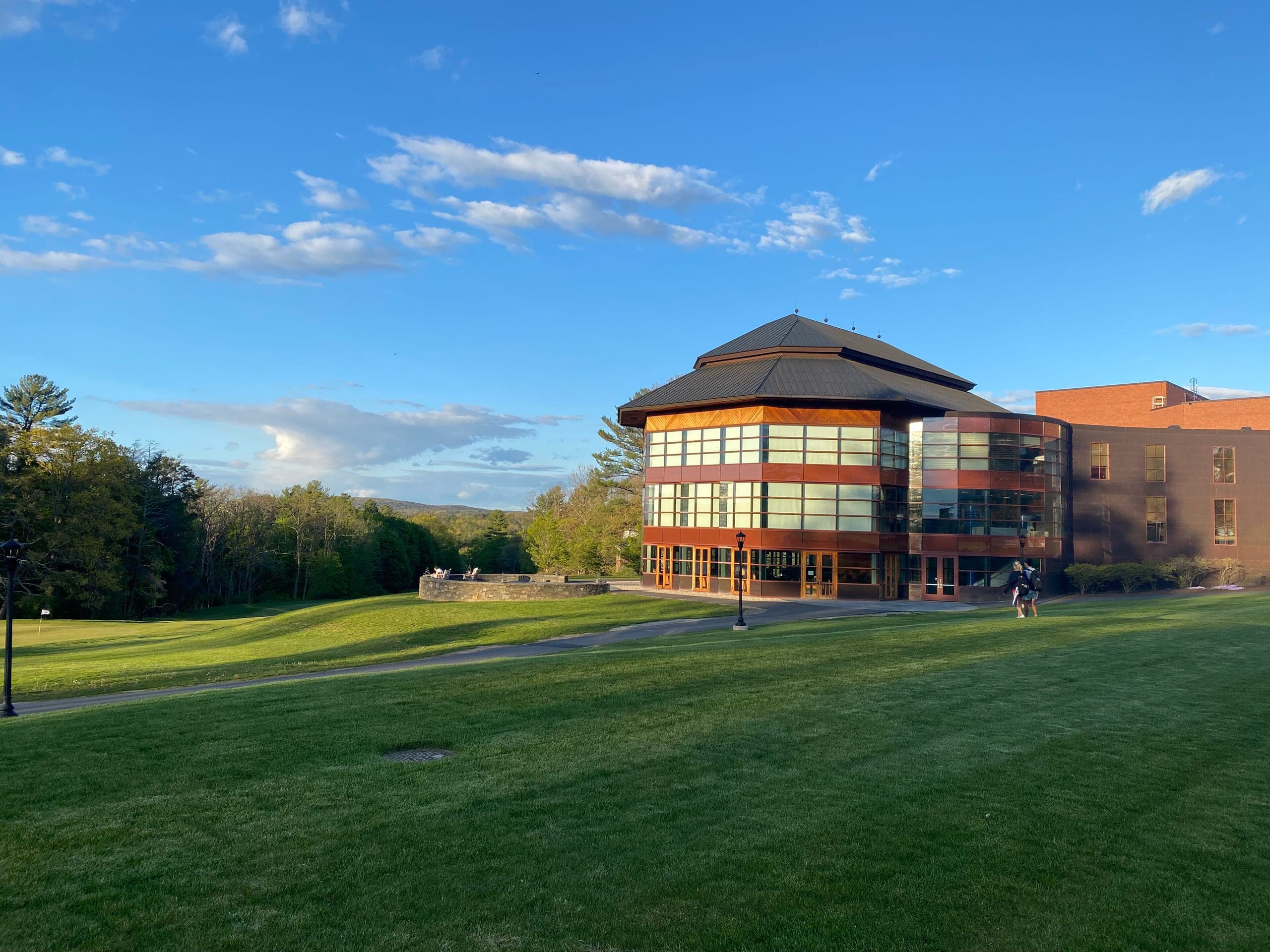 Hotchkiss’s music wing, a brick-and-glass building with a tiered roof, beside a wide lawn under a blue sky