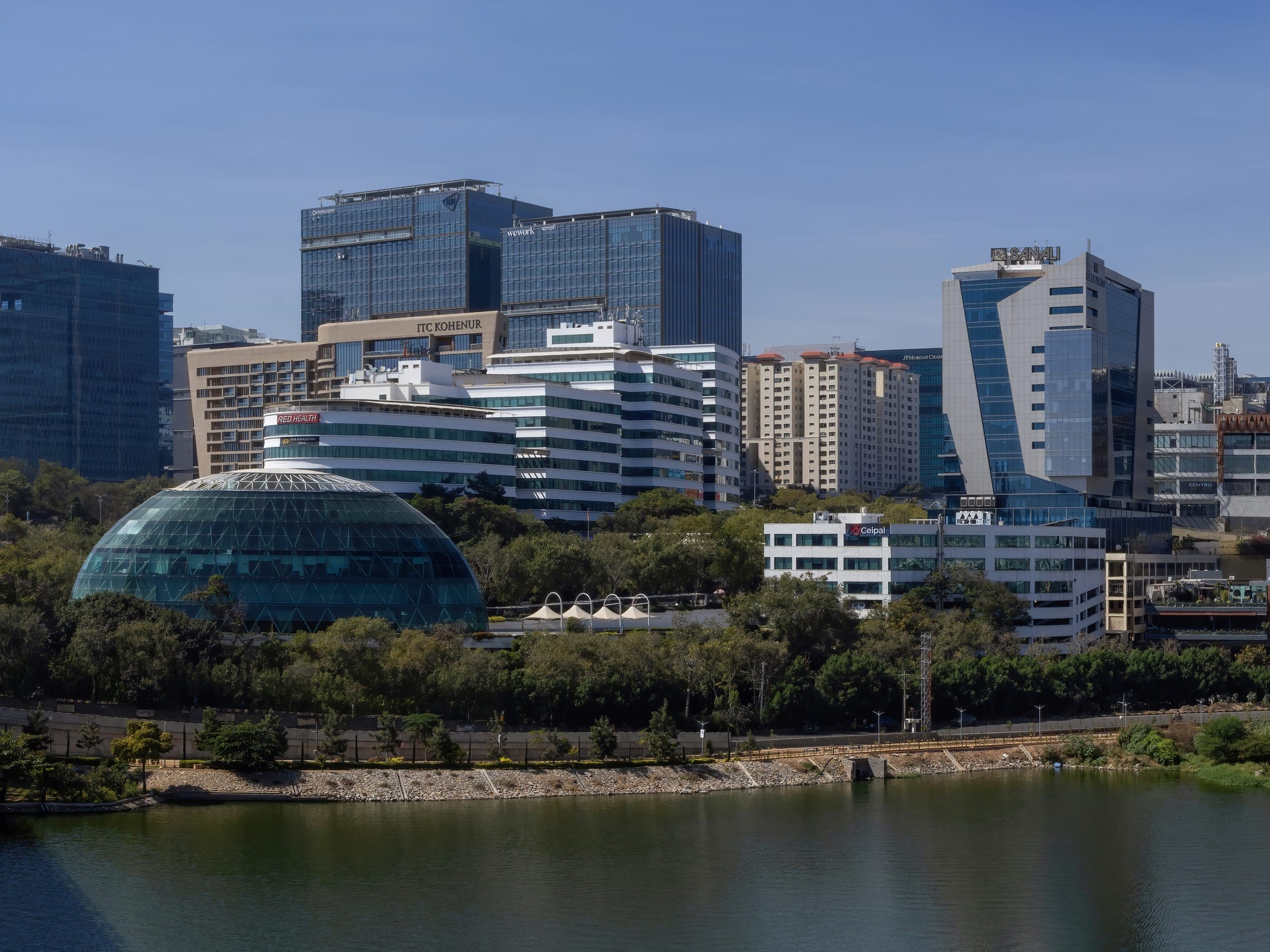 Glass office towers and a domed building on the shore of a lake in Hyderabad