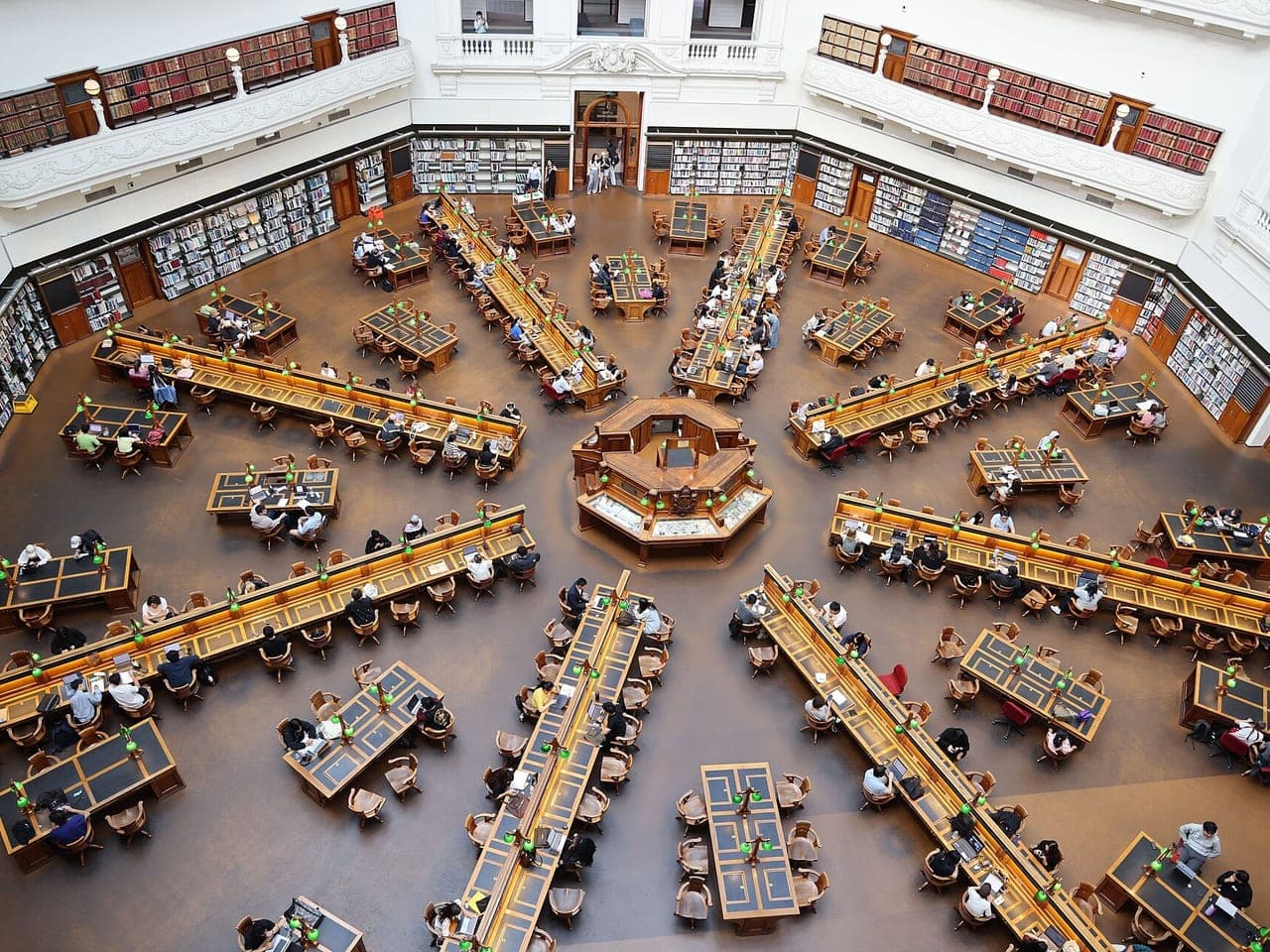 Looking down into a domed reading room, with long desks spreading out like spokes