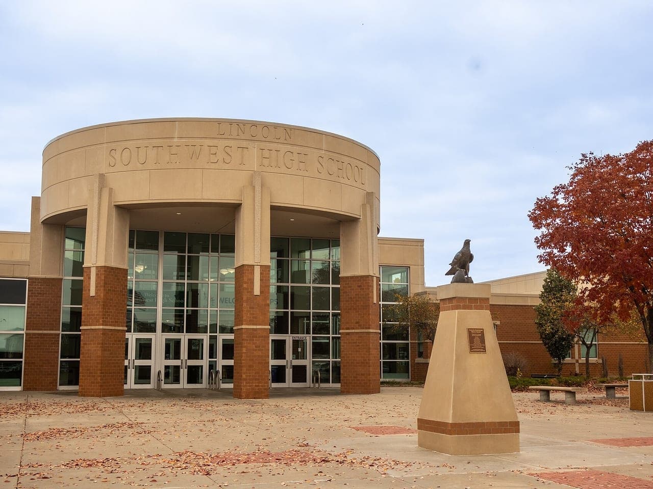 The entrance of Lincoln Southwest High School in Nebraska, with an autumn tree beside it