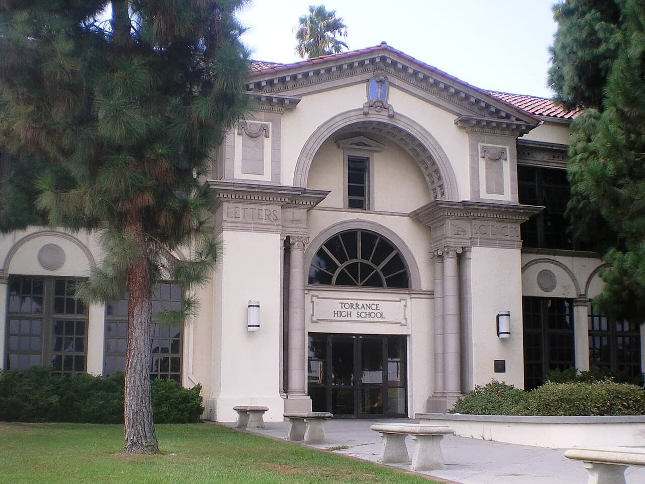 The arched entrance of Torrance High School in California, framed by trees.